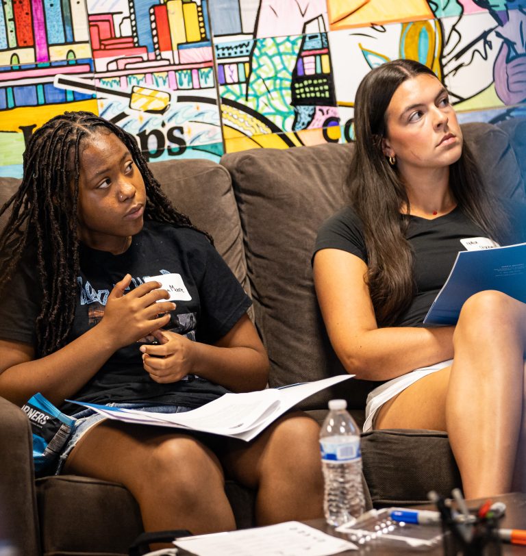 Sanaa Moore and Lydia Stumpf listen intently.